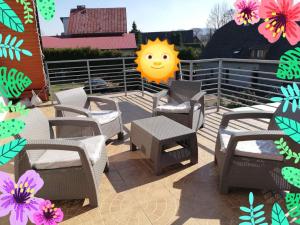 een terras met stoelen en een zonnebord bij Pokoje gościnne Alicja in Kudowa-Zdrój