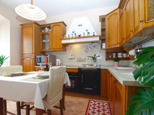 a kitchen with wooden cabinets and a table with chairs at Apartment Mile 1872 in Fažana +19 photos