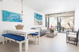 sala de estar con mesa blanca y sillas en Mirador Blue D - Cala Sant Vicenç, en Cala de Sant Vicent