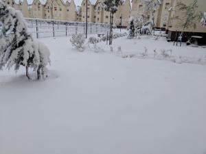 a yard covered in snow with a building in the background at Bel appartement à Ifrane in Ifrane
