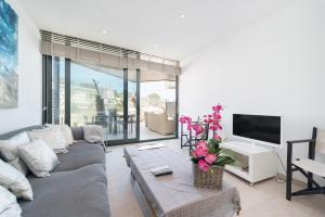 a living room with a couch and a tv at Mirador Blue D - Cala Sant Vicenç in Cala de Sant Vicenc