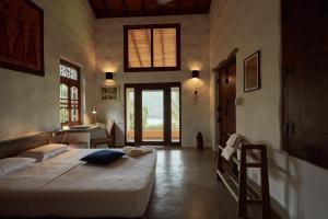 a bedroom with two beds and a sink and a desk at Bamboo Villa Kandy in Digana