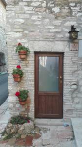 uma porta de madeira ao lado de um edifício de pedra em CASA DEL FRATE em Assis