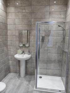 y baño con ducha y lavamanos. en Serendipity House, en Derry Londonderry