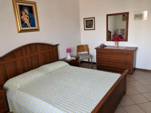 een slaapkamer met een bed, een dressoir en een spiegel bij Castellan I in Grado