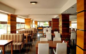 a restaurant with white chairs and tables and tables and benches at Expo Park Hotel in Antalya