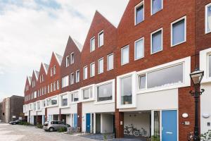 a brick building with white windows on a street at Canal House - Homestay in Alkmaar