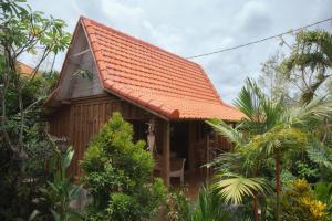 una pequeña casa con techo de baldosa naranja en Pande Homestay, en Canggu