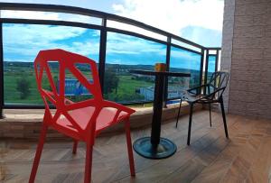 two red chairs and a table in front of a large window at 墾丁秋莊會館 附限量停車位 不保證有位置 無法事先預留 背包房無車位 預訂後記得加Line聯繫 in Hengchun