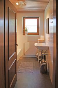 een badkamer met een wastafel, een toilet en een deur bij Appartement Herzogbauer in Saalfelden am Steinernen Meer