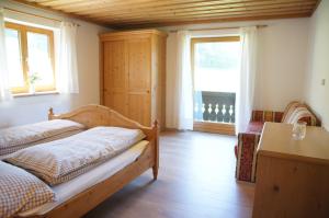 een slaapkamer met een bed, een bureau en ramen bij Appartement Herzogbauer in Saalfelden am Steinernen Meer