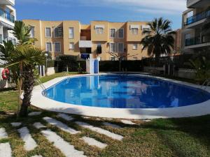 a large blue swimming pool in front of some buildings at Riumar Solo Familias Serviplaya in Playa de Xeraco
