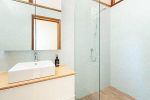 La salle de bains est pourvue d'un lavabo et d'une douche. dans l'établissement Sunny Family Beach House, à Sydney