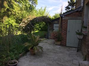 a backyard with a brick building and a garage at Chez Mémère Hélène in Sormonne