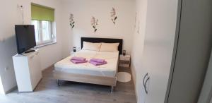 Postel nebo postele na pokoji v ubytování Apartmani Orhideja