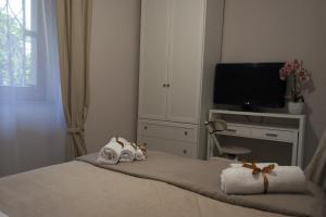 a bedroom with a bed with towels and a tv at L' albero di giada in Caserta