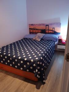 a bed with a black and white polka dot sheets at Avenue Rooms in Valencia