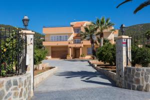 una entrada que conduce a una casa con una puerta en Villa Palmera en Ibiza