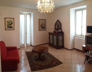 a living room with a red couch and a table at Casa della Nonna 2 in Gargnano +5 photos
