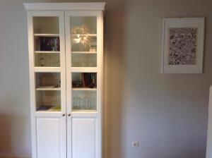 un armario blanco con puertas de cristal en una habitación en Ghenttower, en Gante