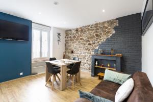 sala de estar con mesa y chimenea en Les Bois Flottés, en Saint-Malo