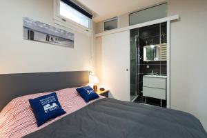 Un dormitorio con una cama con almohadas azules. en Les Bois Flottés, en Saint-Malo