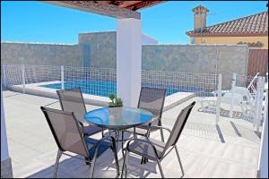 a patio with a table and chairs and a pool at Chalet Ermita in Conil de la Frontera