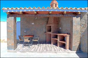 a patio with a table and chairs in a building at Chalet Ermita in Conil de la Frontera