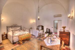 a large living room with a bed and a table at Casale del Forno in Andrano