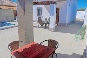 a red table and two chairs on a patio at Chalet Ermita in Conil de la Frontera