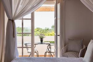 a bedroom with a bed and a table and a patio at Quinta da Lua in Tavira