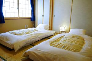 
Tempat tidur dalam kamar di Ryokan Kamogawa Asakusa
