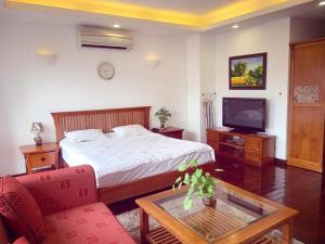 a bedroom with a bed and a tv and a table at Beautiful APT in Ha Noi KT in Hanoi