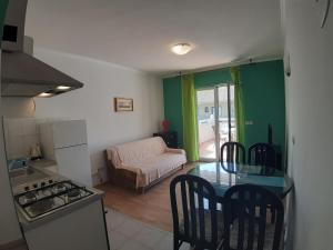 een keuken met een tafel en stoelen in een kamer bij Apartments and Rooms Dobrila in Jelsa