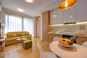 uma cozinha e uma sala de estar com mesa e cadeiras em SunRay em Tivat