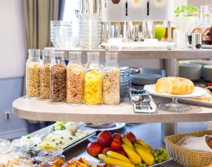un buffet de alimentos con tarros de cereales y fruta en Unitas Hotel en Praga