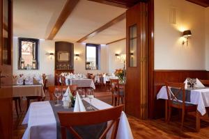 ein Restaurant mit Tischen und Stühlen sowie weißen Tischdecken in der Unterkunft Hotel Eisenbahn in Karlstadt