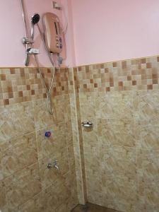 eine Dusche im Bad mit einer gefliesten Wand in der Unterkunft Aaliyahs Place in Puerto Princesa