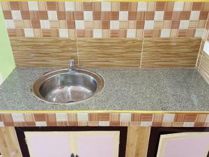 eine Metallspüle in einer Theke in einer Küche in der Unterkunft Aaliyahs Place in Puerto Princesa