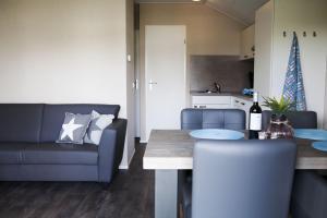 a living room with a table and a couch at 4 pers. Veluwelounge in Voorthuizen