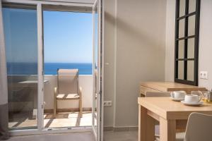 a dining room with a view of the ocean at Fata Morgana Studios & Apartments in Frangokastello