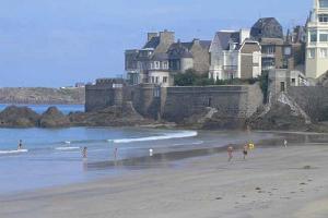 eine Gruppe von Menschen an einem Strand mit einem Gebäude in der Unterkunft Les Bois Flottés in Saint-Malo