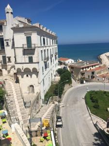 a building on the side of a road next to the ocean at Residence Ducale in Rodi Garganico
