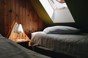 Un dormitorio con una cama y una lámpara y una ventana. en Kamienica Sporting, en Międzyzdroje