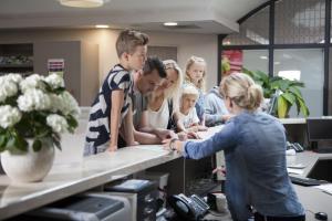 a group of people standing around a counter in an office at 6 pers. Veluwelounge + Wellness in Voorthuizen