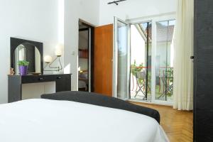 ein Schlafzimmer mit einem Bett und einem Balkon in der Unterkunft Villa Palma in Petrcane