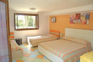 una camera da letto con due letti e una finestra di Borgo Console a Porto Cesareo