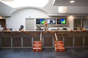 a waiting room with a counter and two televisions at 6 pers. Veluwelounge + Wellness in Voorthuizen