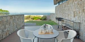 a patio with a table and chairs on a balcony at Harbour House Hotel - Le Paradis Apartments in Hermanus