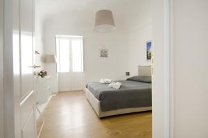 a white bedroom with a bed and a window at La terrazza di Archimede- Ortigia Holidays in Syracuse